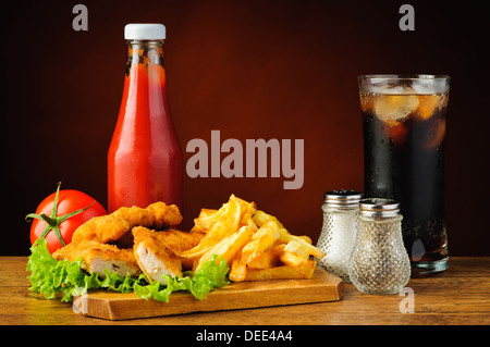 Stillleben mit Fast-Food-Menü, Hähnchen-Nuggets, Pommes, Cola und Tomaten ketchup Stockfoto