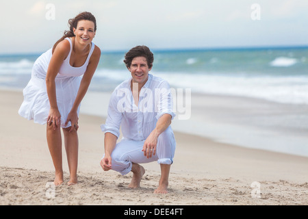 Ein glücklich Mann und Frau Junge Paare, die Spaß im Sand von einem sonnigen tropischen Strand Stockfoto