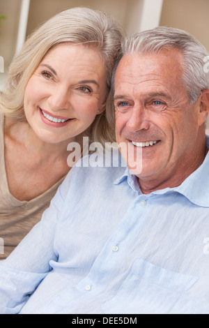 Glücklich senior Mann und Frau paar sitzen gemeinsam zu Hause lächelnd und glücklich Stockfoto
