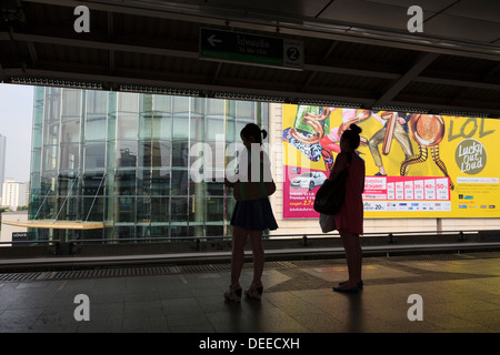 Zwei asiatische Frauen warten auf eine Skytrain Haltestelle Siam. Bangkok. Thailand. Stockfoto