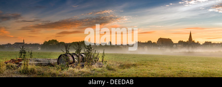 Malmesbury, Wiltshire. Glocken der Kirche über die Wiese auf einem nebligen September Dawn. Stockfoto