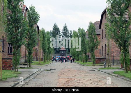 Gefangener Hütten wo Juden gehalten wurden, vor dem die Gaskammern und die Wachen Wachturm in der Ferne. Stockfoto