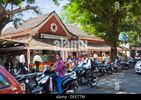 Verkehr auf der Straße mit Restaurant im Hintergrund, Gujarat Sweet Mart, Nord-Goa, Panaji, Goa, Indien Stockfoto