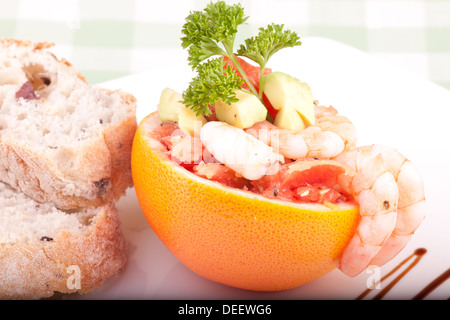 Makro des Grapefruit-Salat mit Garnelen auf Teller mit Brot serviert. Stockfoto