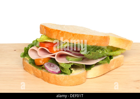 Schinken und Salat-Sandwich auf einem Holzbrett vor einem weißen Hintergrund Stockfoto