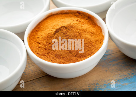 rohe organische getrocknete Mangostan Fruchtpulver in eine kleine Keramikschale Stockfoto