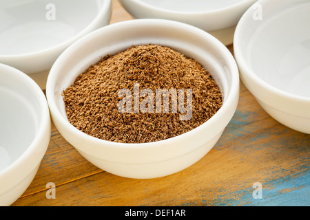 Rohe Bio getrockneten Noni (Morinda Citrifolia), Pulver Obst in eine kleine Keramikschale Stockfoto