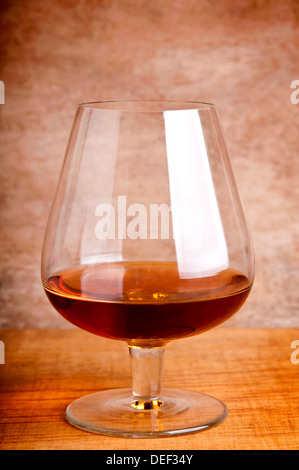 Glas Cognac auf einem hölzernen Hintergrund Stockfoto