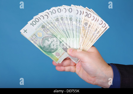 Das Unternehmer Hand mit Polnisch Geld Banknote blau Hintergrund Stockfoto