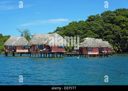 Eco Resort mit strohgedeckten Hütten oberhalb des Meeres auf der tropischen Insel Bastimentos, Karibik, Bocas del Toro, Panama Stockfoto