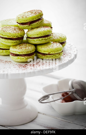 Französische Macarons in grün mit Kakaopulver Stockfoto