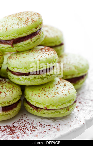 Französische Macarons in grün mit Kakaopulver Stockfoto