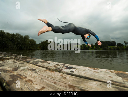 Triathlet Tauchen in Aichstruter Stausee, Welzheim, Baden-Württemberg, Deutschland Stockfoto