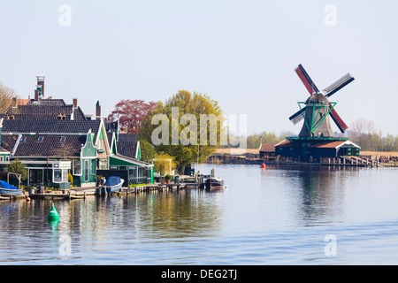 Historische Windmühlen und Häuser in Zaanse Schans an den Ufern des Flusses Zaan, in der Nähe von Amsterdam Zaandam, Niederlande Stockfoto