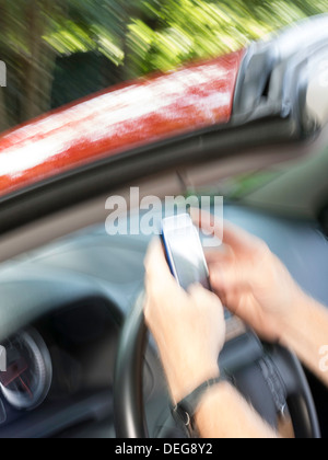 Männliche Hände SMS während der Fahrt Stockfoto