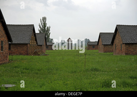 Gefangener Hütten wo Juden gehalten wurden, vor dem die Gaskammern und die Wachen Wachturm in der Ferne. Stockfoto