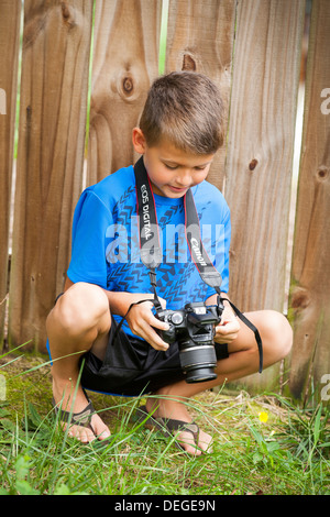 Junge in seiner Kamera schaut Stockfoto