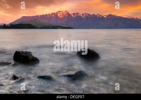 Die Remarkables Bergkette leuchtet bei Sonnenuntergang über Lake Wakatipu, Queenstown, Südinsel, Neuseeland. Stockfoto