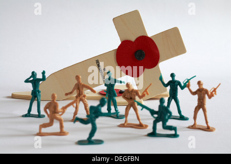 Modell Spielzeugsoldaten in einer Schlacht vor British Legion Red Poppy In Erinnerung Kreuz auf weißen Hintergrund Stockfoto