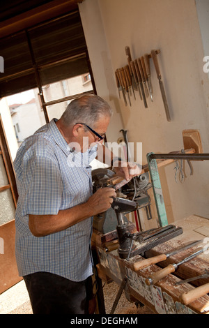 Alten senior Handwerker arbeiten auf der Drehbank in seiner Werkstatt in der Brianza in der Nähe von Mailand, Italien Stockfoto