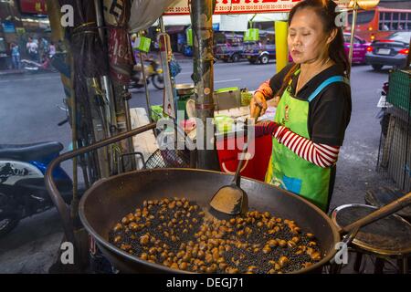 18. September 2013 - Bangkok, Thailand - A-Lieferanten röstet Kastanien an einem Straßenstand im Abschnitt Chinatown von Bangkok. Thailand im allgemeinen und vor allem Bangkok hat eine lebendige Tradition der Straße Nahrung und Essen auf der Flucht. In den letzten Jahren ist so etwas wie ein Wahrzeichen Bangkoks Streetfood und in glänzenden Reisemagazine und auf den Seiten der New York Times über die geschrieben wird. (Bild Kredit: Jack Kurtz/ZUMAPRESS.com ©) Stockfoto