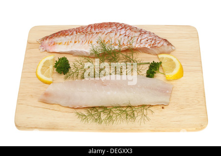 Rohe Filets von Rotbarbe Fisch auf einem Holzbrett mit Zitrone, Petersilie und Fenchel isoliert gegen weiß Stockfoto