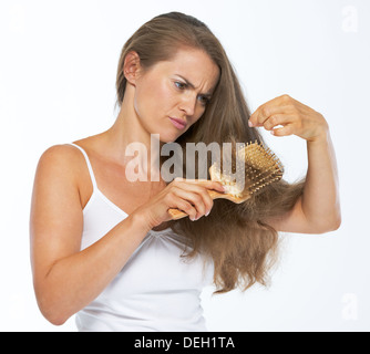 Frustrierte Frau, die auf Haarspitzen Stockfoto