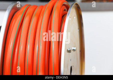 der orange Kunststoffschlauch industrielle Detail aufgerollt Stockfoto