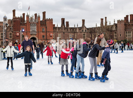 Die Menschen genießen Eislaufen am temporären Winter Eisbahn vor Hampton Court Palace, größere London, UK Stockfoto