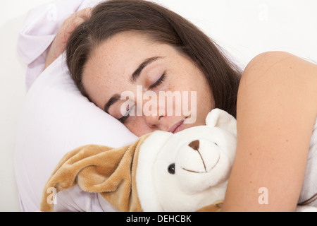 Frau schläft mit einem Teddy-Bären Stockfoto