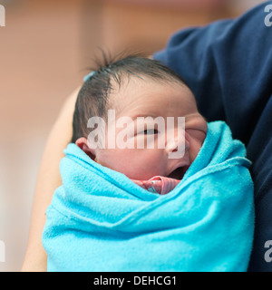 Asiatische neugeborenes Mädchen lächelnd in den Armen des Vaters, im Krankenzimmer Stockfoto