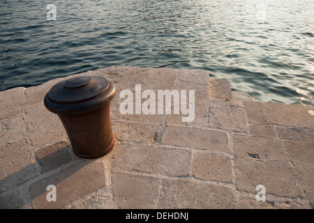 Alte verrostete Metall Poller stehen auf Stein Pier in Montenegro Stockfoto