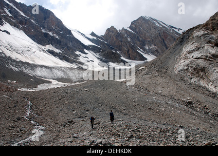 Ein Trekker und lokalen Führer steigen die unteren Hänge des Chimtarga Passes in den Bergen Fann von Tadschikistan Stockfoto