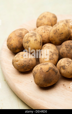 Eine Komposition aus frischen, leckere und appetitliche Maris Piper Kartoffeln auf einer Holzfläche zum Kochen bereit Stockfoto