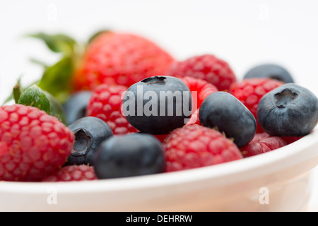 Ein frisches appetitliches Frühstücksbuffet Schüssel voll von Himbeeren, Erdbeeren und Heidelbeeren angeordnet auf einem Holzbrett Stockfoto