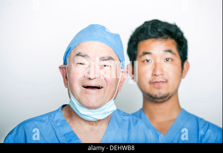 Ein Porträt Senior Erwachsenen Chirurg einen jungen asiatischen Arzt Stockfoto