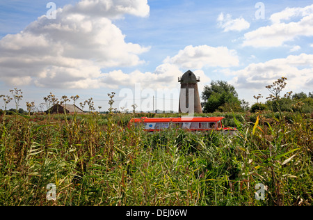 Ein Blick auf einen Kreuzer auf den Norfolk Broads, vorbei an der redundanten Entwässerung Mühle am Clippesby, Norfolk, England, Vereinigtes Königreich. Stockfoto