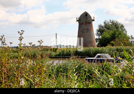 Ein Blick auf die redundante Clippesby Entwässerung Mühle durch den Fluss Bure auf den Norfolk Broads, England, Vereinigtes Königreich. Stockfoto