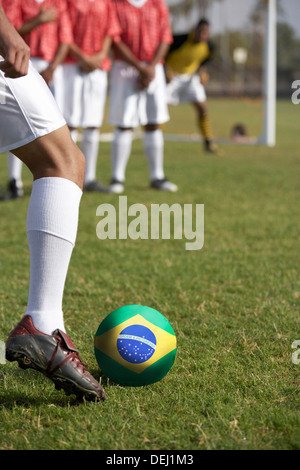 Fußball-Spieler, die Vorbereitung auf eine Freistoß-Front brasilianische Flagge Stockfoto