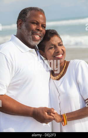 Glücklich romantische senior afroamerikanische Mann und Frau Paar halten die Hände auf einem einsamen tropischen Strand Stockfoto