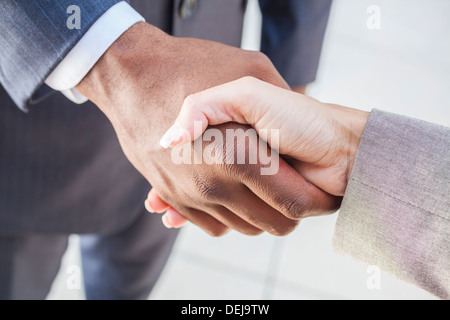 Afrikanische amerikanische Geschäftsmann oder Mann Händeschütteln mit einer Geschäftsfrau oder Frau weiß Kollegin machen ein Geschäft Stockfoto