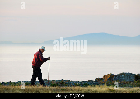 Älterer Mann zu Fuß in der Oak Bay Marina am Sonnenaufgang-Victoria, British Columbia, Kanada. Stockfoto