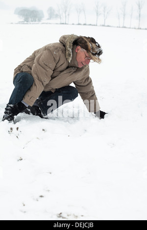 Senior woman mit verletzten Bein auf Schnee. Stockfoto