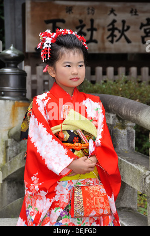 Ein junges japanisches Mädchen posiert in traditioneller Kleidung. Stockfoto