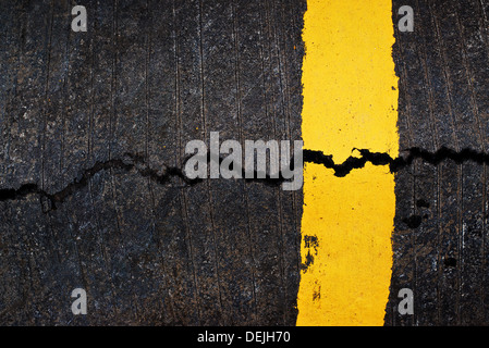 Gelbe Linie auf rissige Asphaltstraße, städtische Textur Stockfoto