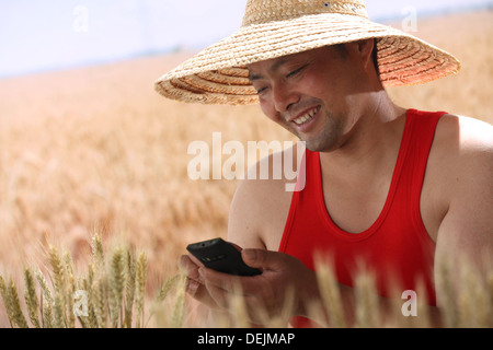 Landwirt Holding Handy im Weizenfeld Stockfoto