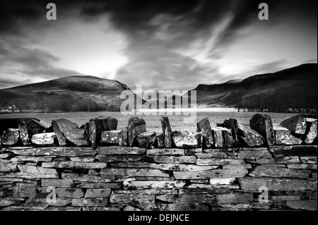 Steinmauer und Sonnenuntergang in North Wales, UK, Gipfel des Snowdonia im Hintergrund Stockfoto