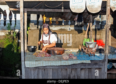 Muslimische Frau verkaufen Huhn an einem Morgen Markt. Hua Hin Village, in der Nähe von Lovina, Bali, Indonesien Stockfoto