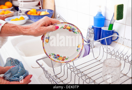 Abgeschnitten Bild senior Frau arrangieren Tellerhalter Küchentheke Stockfoto