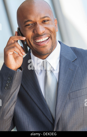 Erfolgreicher afroamerikanischer Geschäftsmann oder Mann in einem Anzug in einer modernen Stadt reden auf seinem Handy Stockfoto